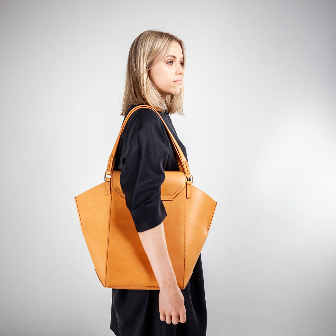 Modernes Mädchen mit camelfarbener Handtasche in Trapezform von AGDA.