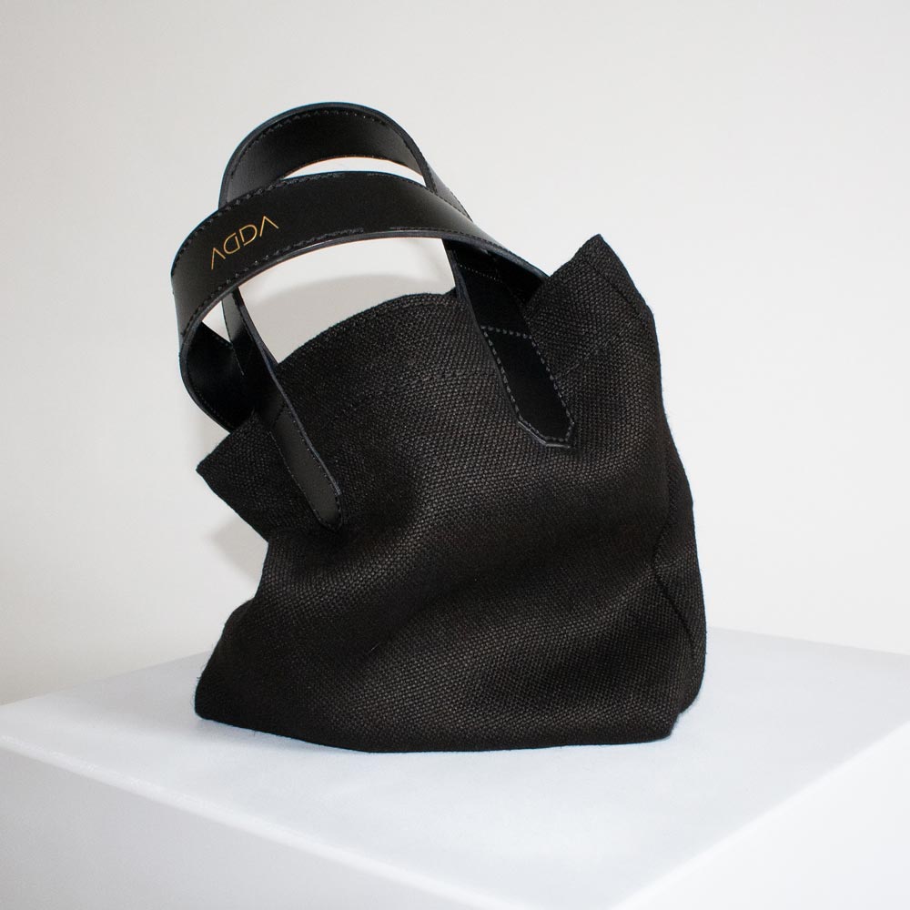 Kleine Tasche aus Canvas in Schwarz mit Lederdetails.