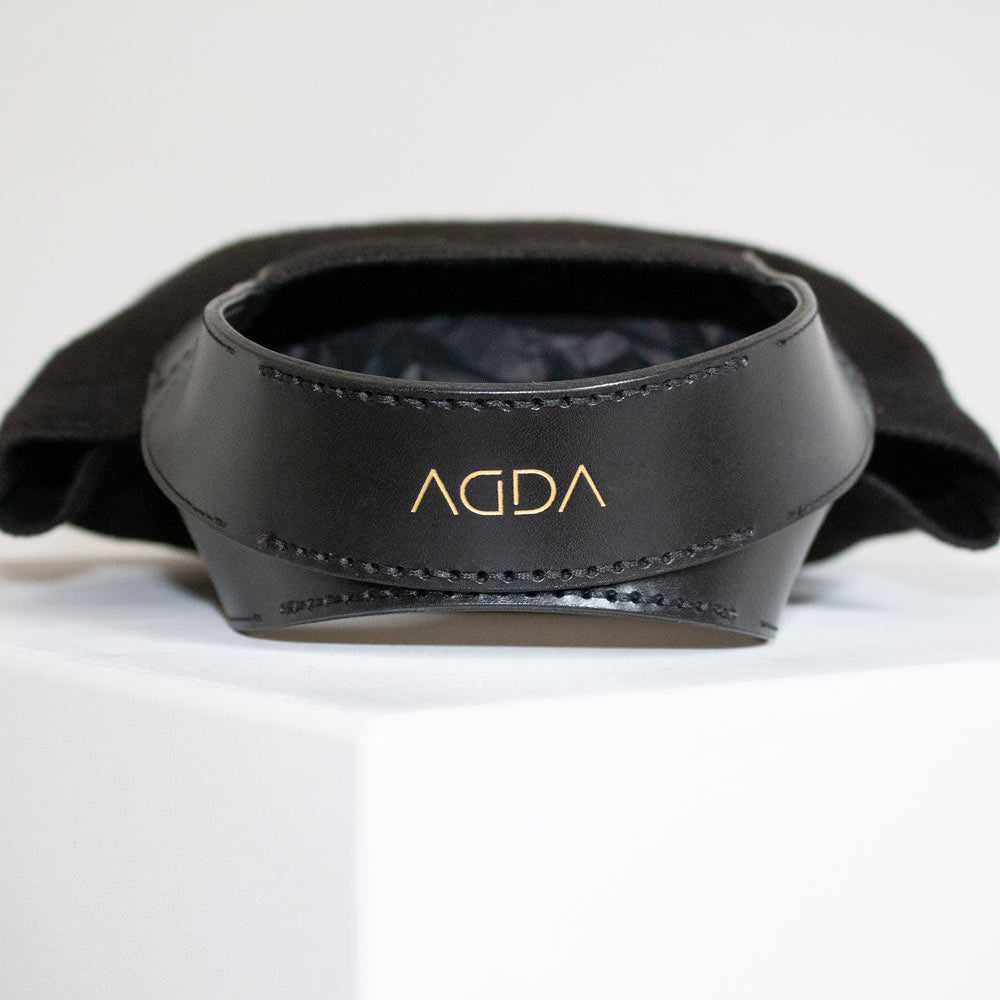 Schwarze Lederträger mit goldener Prägung von AGDA.