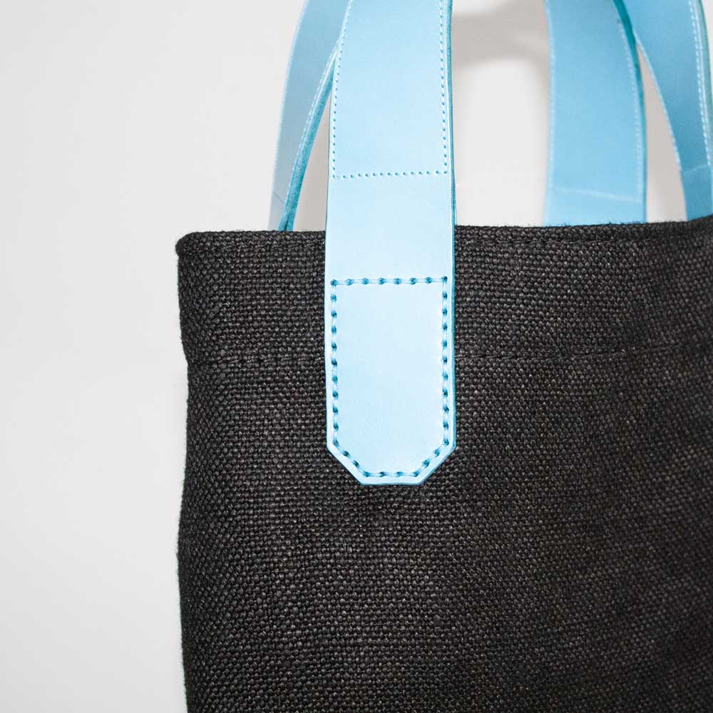 Details an Mini Tasche: Sattlernaht auf blauem Leder..